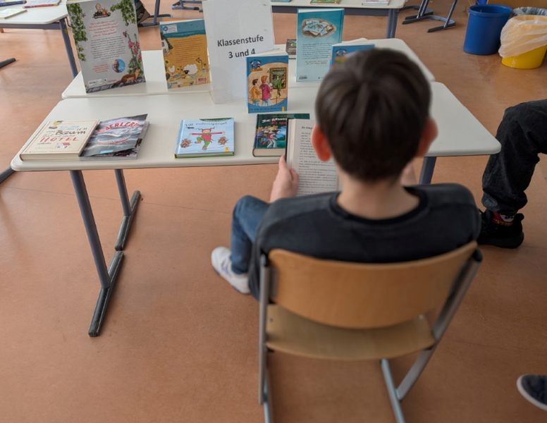 Kind liest in einem Buch der Ausstellung