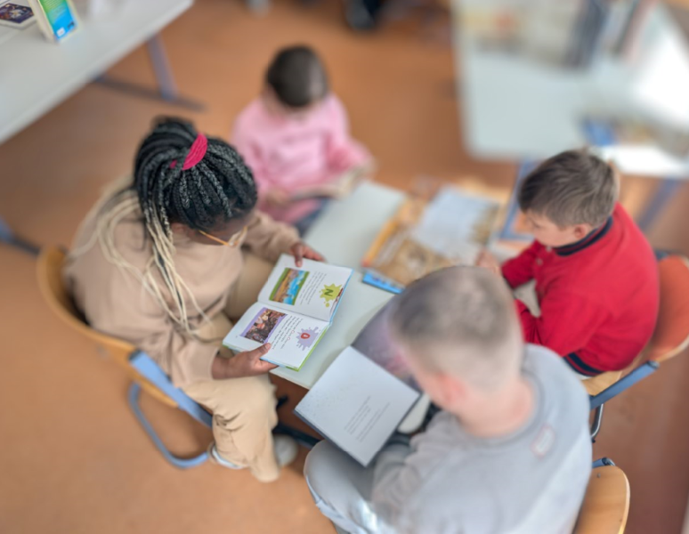 Vier Kinder lesen gemeinsam in Büchern der Ausstellung
